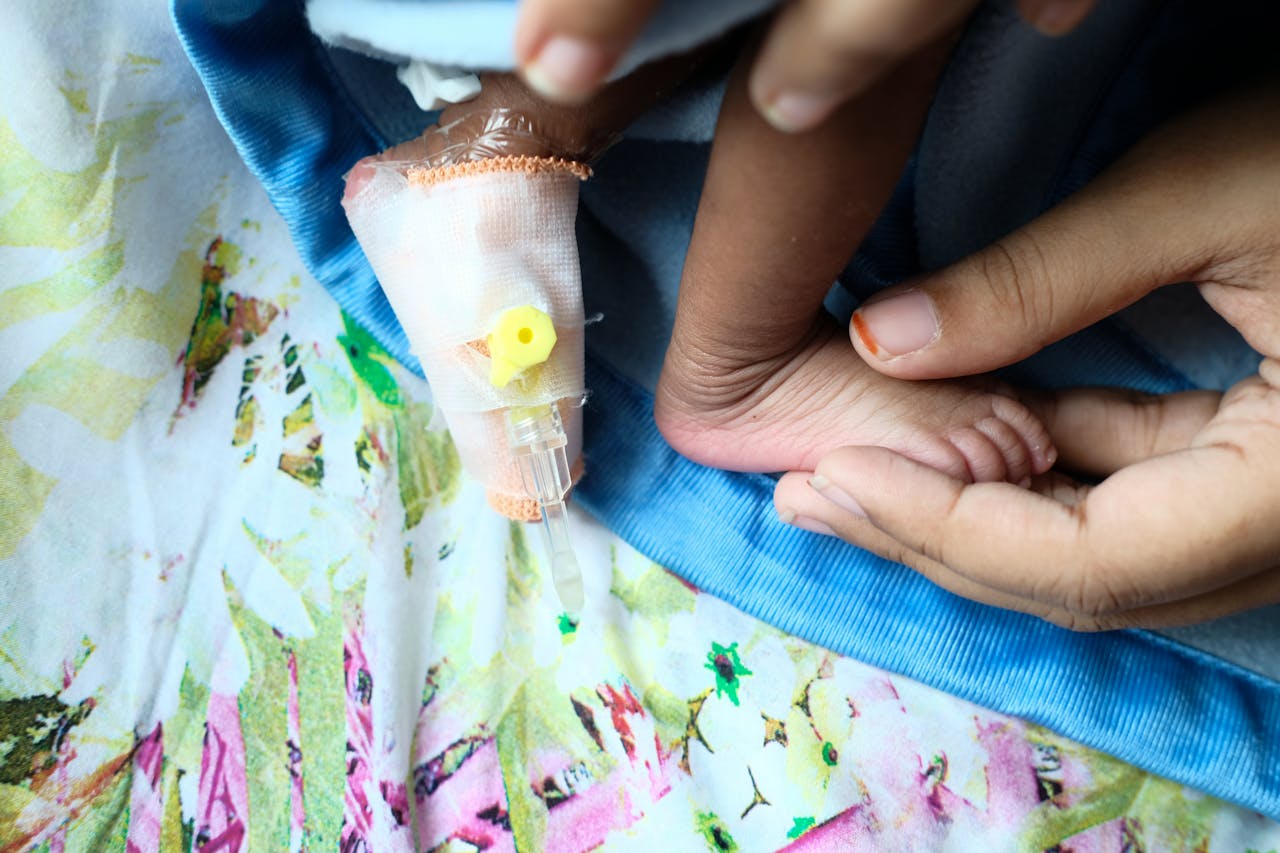 Close-up of a baby’s foot and IV bandage, symbolizing gentle care and love.